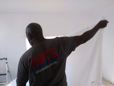 “Handymen on the Spot professional completing an interior painting project, carefully painting along