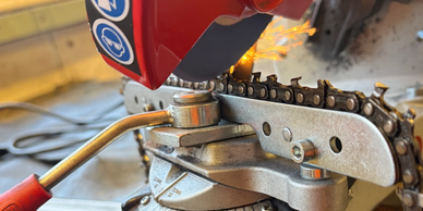 Chainsaw sharpening with sparks flying.
