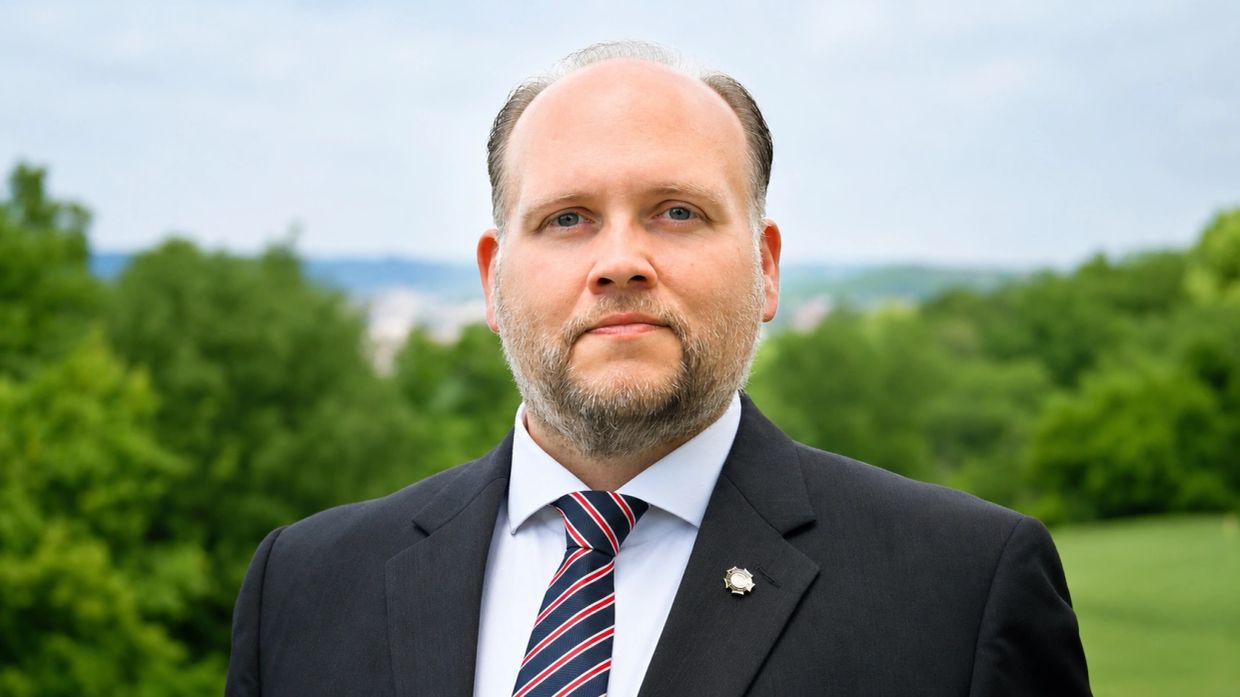 Confident man in a suit with striped tie outdoors.