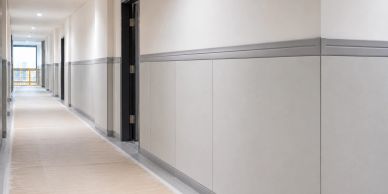 Empty modern hallway with gray and white walls and carpeted floor.