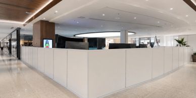 Modern office cubicles with white partitions in a spacious area.