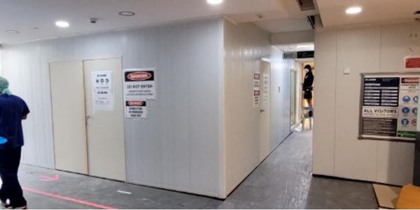 Hospital hallway with warning signs and staff.