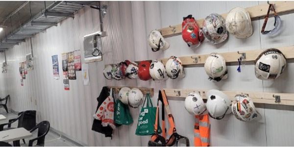 Construction helmets and safety gear hanging on the wall.