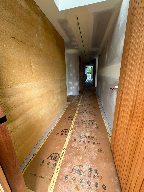 Long narrow hallway under construction with protective floor covering.