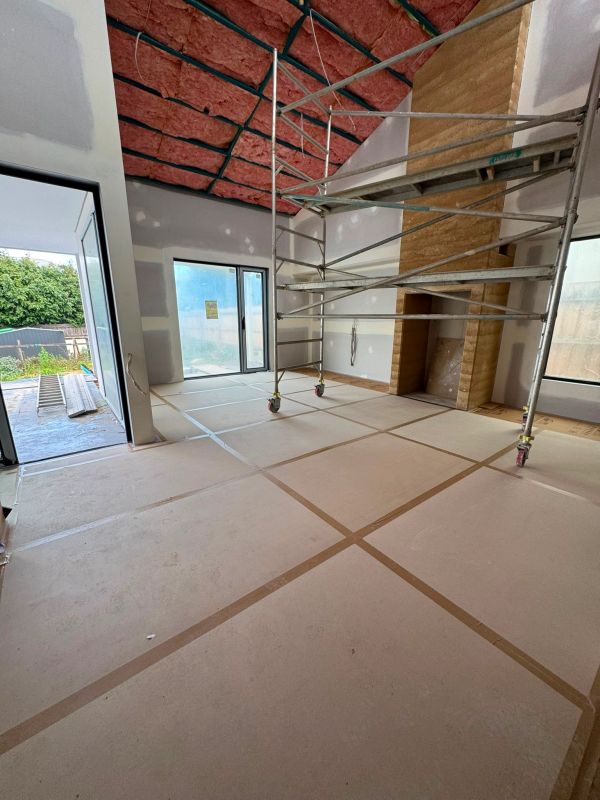 Room under construction with scaffolding and ceiling insulation.