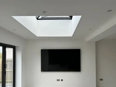 Modern living room with skylight and wall-mounted TV.