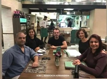 Five people sitting around a table in a restaurant.
