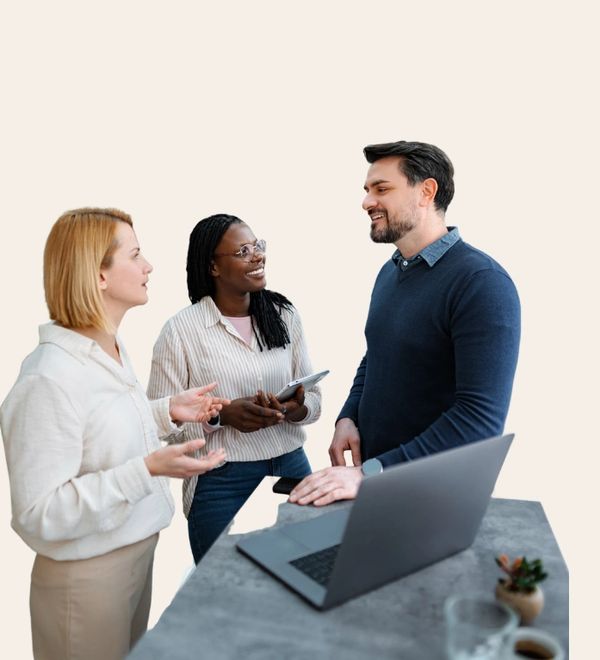 Three colleagues engaged in a friendly discussion around a laptop.