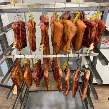 Smoked meat hanging on racks for curing.