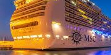 MSC cruise ship docked at night with illuminated lights.