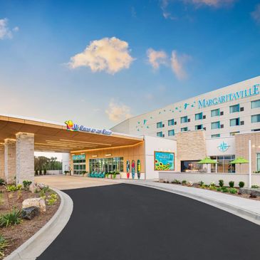Entrance of Margaritaville hotel with bright blue sky and welcoming design.