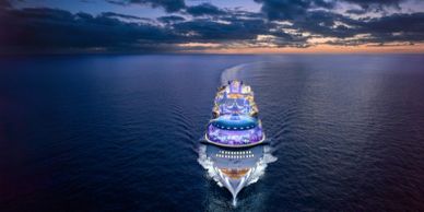 Cruise ship sailing at dusk on calm ocean waters.