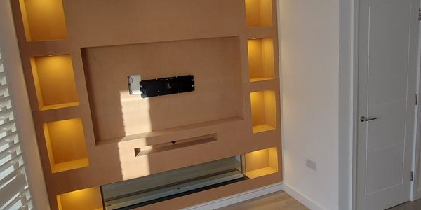 Modern wall unit with built-in illuminated shelves and TV mount.