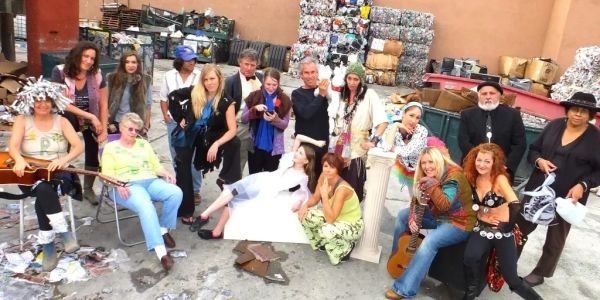Group of diverse people in a colorful, eclectic setting outdoors.