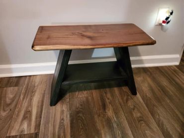 Wooden bench with a dark base and brown top.