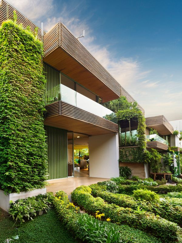 Modern eco-friendly house with vertical gardens and lush greenery.