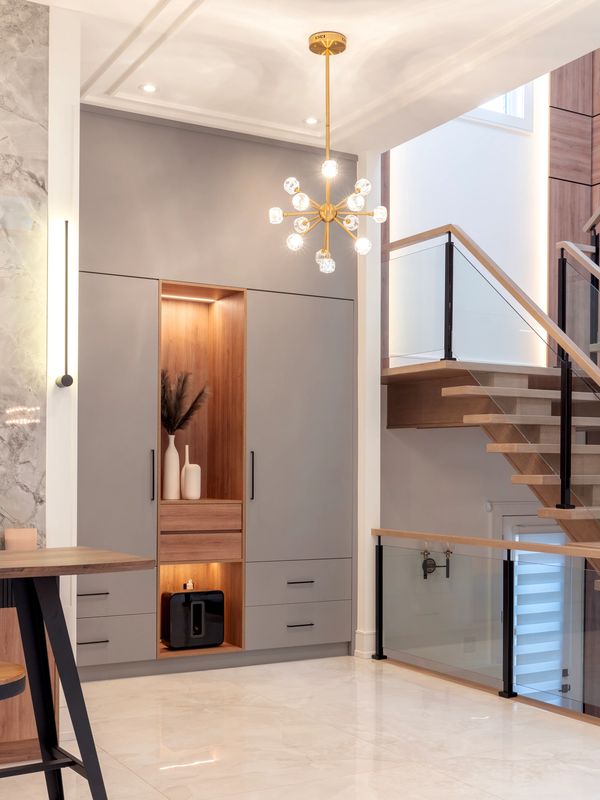 Modern interior with sleek cabinetry, elegant lighting, and a wooden staircase.