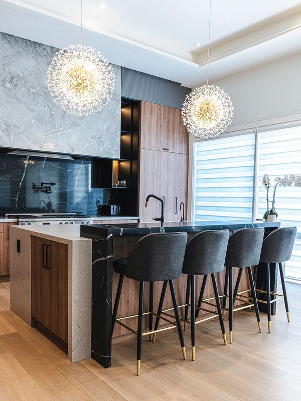 Modern kitchen with marble countertops and stylish pendant lights.
