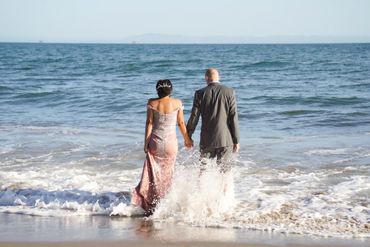 wave splashes around newlyweds on Butterfly beach