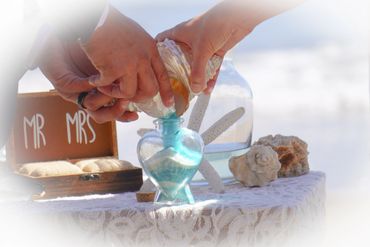 wedding couple pours unity sand ceremony into heart container