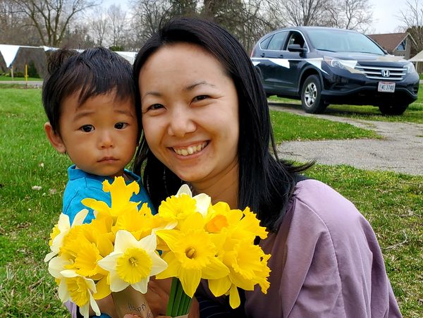 Mom and son smiling with daffodils