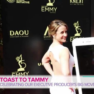 Woman in white dress standing on a red carpet at the Emmy Awards