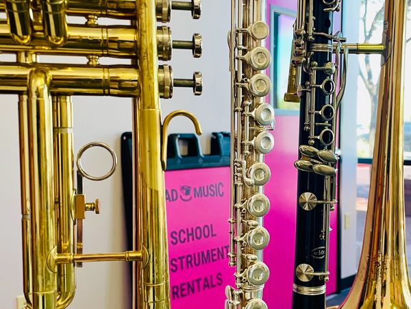 A trumpet, flute, clarinet, and trombone for rent at Mad Music.