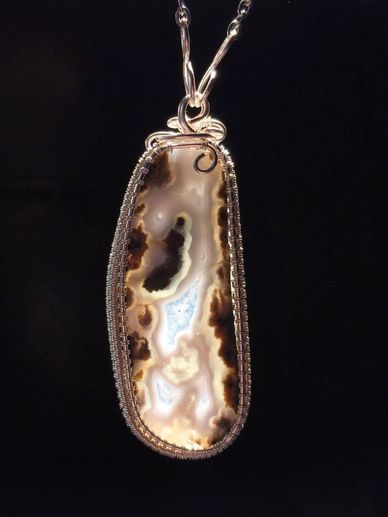 A double-sided, hand-polished mossy agate pendant wrapped in sterling silver by Joe Maddox 