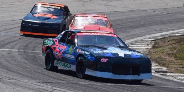 Race cars driving on a track in a competitive race.