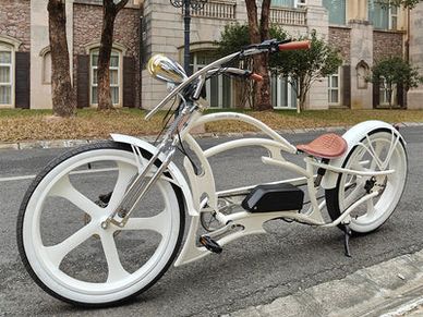 Custom white electric cruiser bike with large wheels and brown leather seat.
