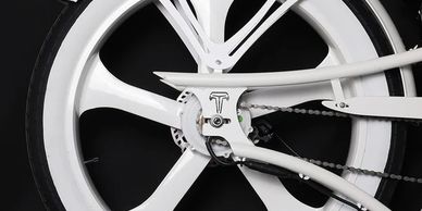 Close-up of a sleek white bicycle wheel with a unique frame design against a black background.
