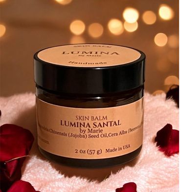 Jar of Lumina Santal skin balm surrounded by rose petals and soft lighting.