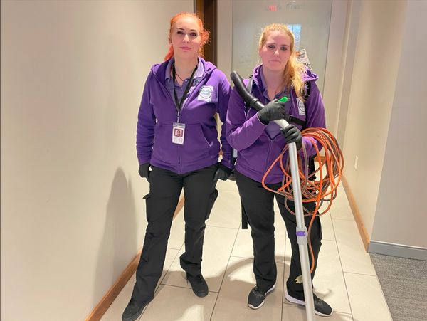 Two ready maids female cleaners holding cleaning machines