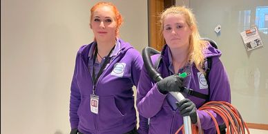 2 Ready Maids employee standing in a hall with their cleaning supplies