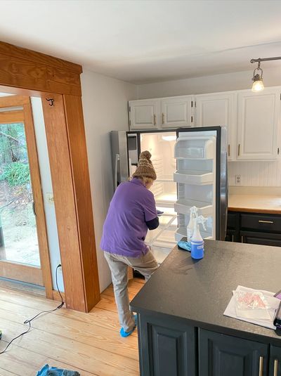 A woman deep cleaning the fridge