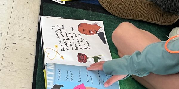 Child reading a colorful book on the floor.