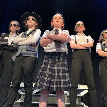 A small group of young people performing on stage in the summer school