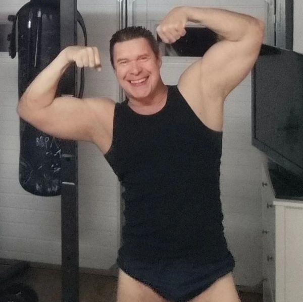 Nico smiling and double biceps posing. Strength training for men 50+, lose belly fat and gain muscle