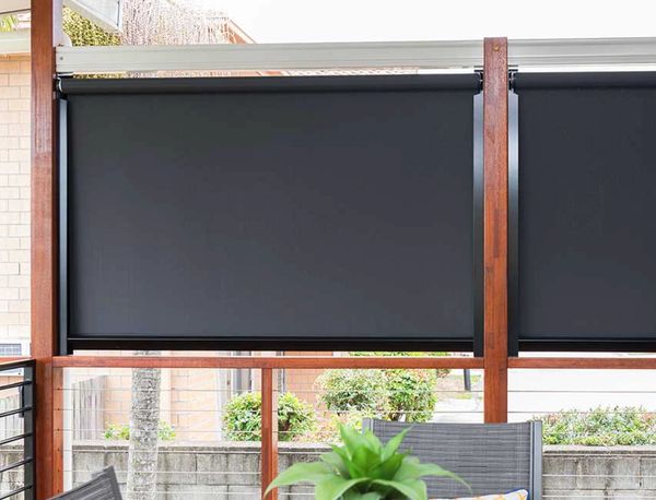 Black outdoor roller blinds on a patio for shade and privacy.