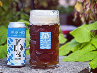 Oktoberfest German-style lager beer from Two Hound Red Brewing Co. in a glass and can.