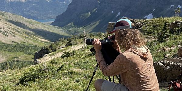 Luca uses a spotting scope to conduct a goat and sheep survey near Siyeh Pass in Glacier.