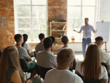 Male speaker giving presentation in the hall at a startup discussing marketing