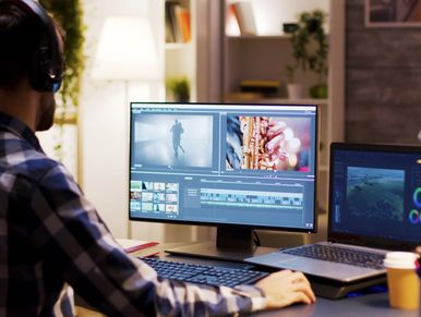 Movie pointing to monitor in home office while working on post-production for a movie.