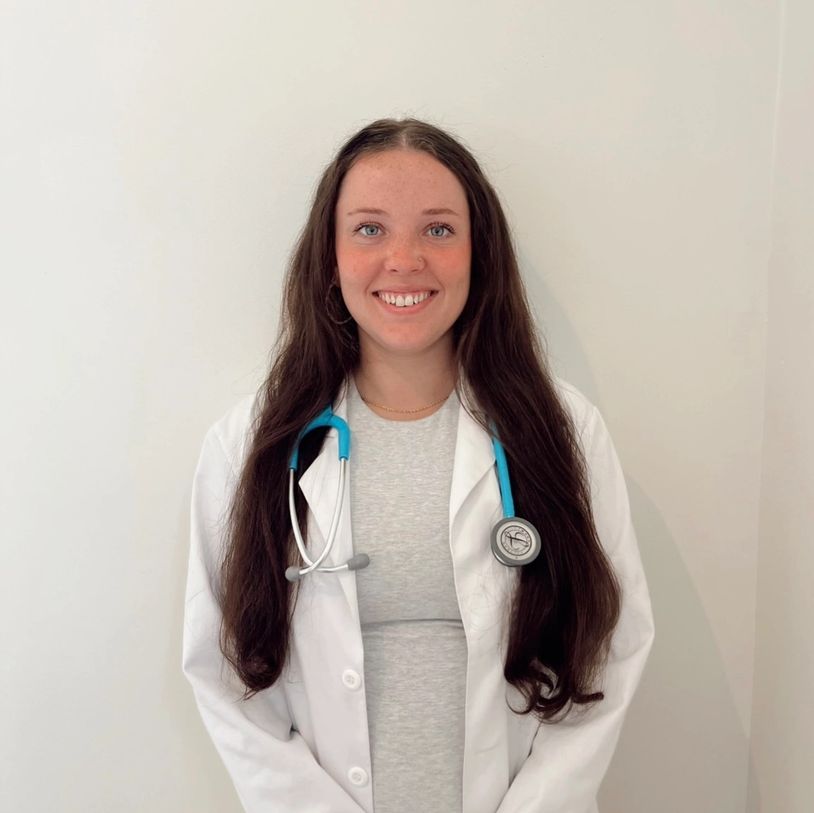 Smiling female doctor with long hair and stethoscope.