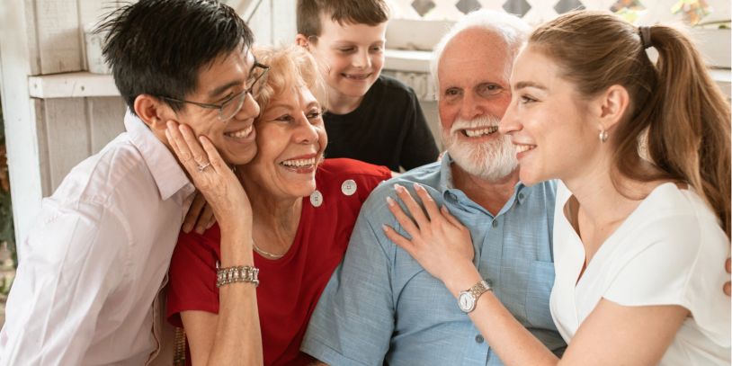 A joyful multigenerational family sharing a warm moment together indoors.