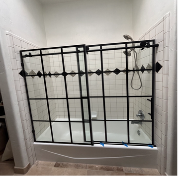 Modern bathroom with grid-style glass shower and gray accent tiles