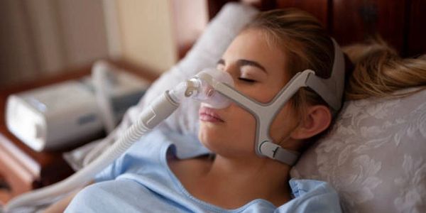 Woman sleeping with CPAP Mask on.