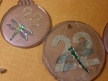 photo of purple tinted resin ornaments with the year "22" in sparkly glitter and transparent dragonf