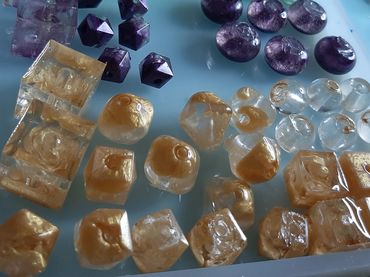 photo of resin beads various shapes in purple, clear, and gold