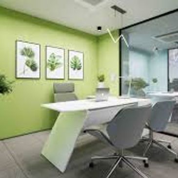 Modern green-themed office meeting room with sleek furniture and nature-inspired decor.